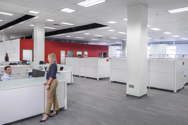 office space in an office building with rows of cubicles and private offices in the background